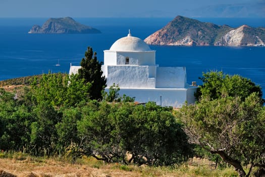 Scenic view of Milos island, Aegean sea and Greek Orthodox traditional whitewashed church. Milos island, Greece