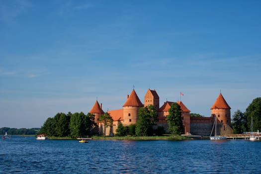 Trakai Island Castle in lake Galve with boats and yachts in summer day with beautiful sky, Lithuania. Trakai Castle is one of major tourist attractions of Lituania