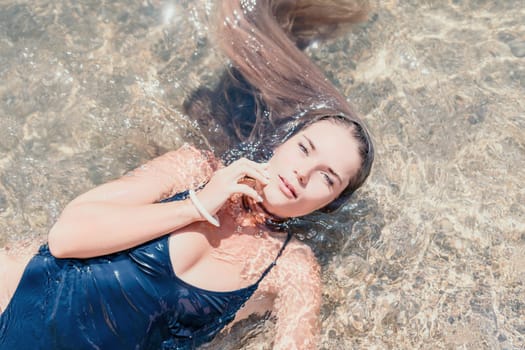 Woman travel sea. Young Happy woman in a long red dress posing on a beach near the sea on background of volcanic rocks, like in Iceland, sharing travel adventure journey