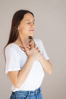 Woman with hands on chest doing breathing exercise at home