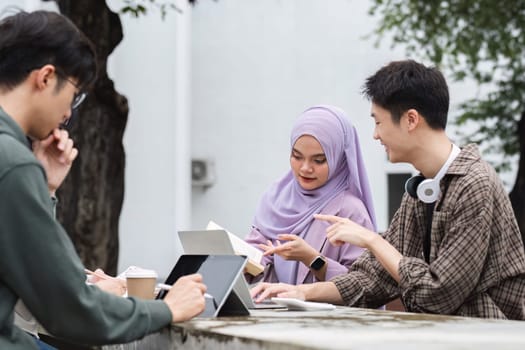 A multiracial group of students at the college, including Muslim and Asian students, sat on benches in a campus break area. Read books or study for exams together..