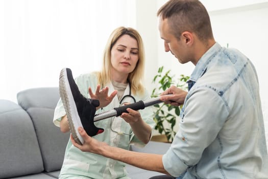 Female physiotherapist adjusting prosthetic leg of patient in hospital. High quality photo