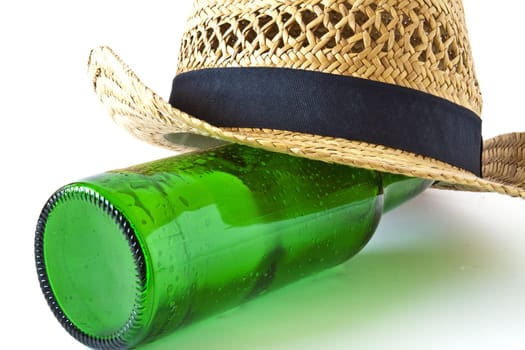 Green beer bottle and a summer straw hat