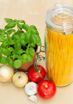 Cooking of Spaghetti - ingredients - pasta, basil, onion, garlic and tomatoes