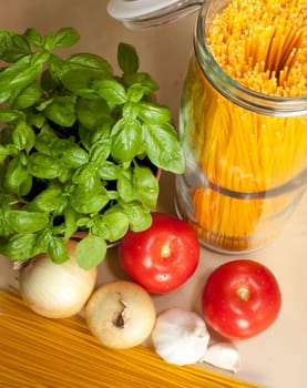 Cooking of Spaghetti - ingredients - pasta, basil, onion, garlic and tomatoes