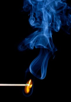 Green coated match head starts to burn with light blue smoke