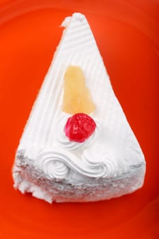 Pastry on a plate with cream and cherry