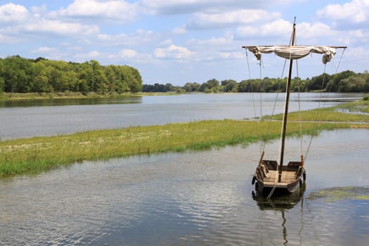 boat or boat anchored on a river against a backdrop of wilderness