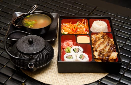 Sushi lunch with soup salad tea and sauce