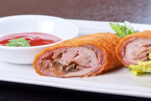 Closeup of rolls from pork meat, champignon mushroom, cheese and sauce