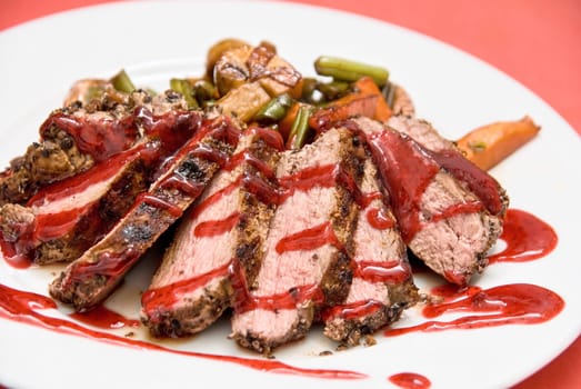 Roasted Beef meat at cranberries sauce with vegetables