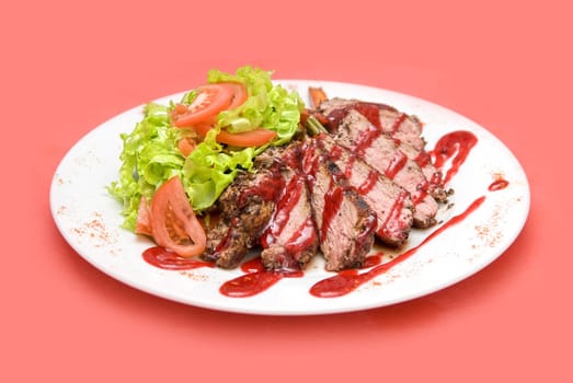 Roasted Beef meat at cranberries sauce with vegetables