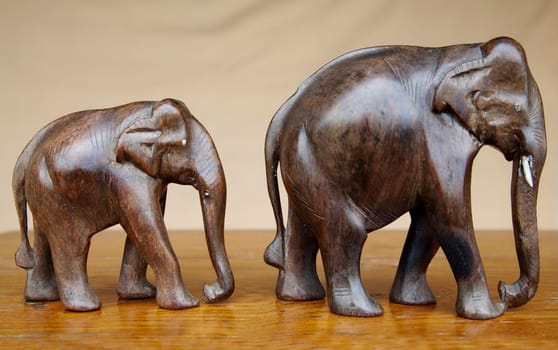 Hand carved from mango tree dark wood with ivory detail on an oak table side board, horizontal with crop space copy space