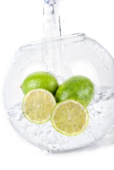 Green limes in water dropped isolated on a white