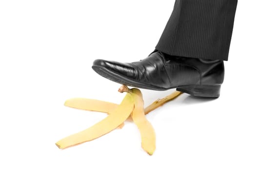 Business boot to step on a banana skin on a white