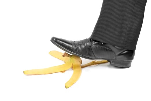 Business boot to step on a banana skin on a white
