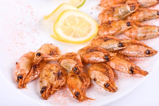 roasted shrimps with lemon closeup isolated on a white background