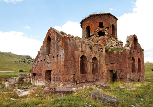 Landscape ruins of dilapidated and derelict Old Red Church Kizil Kilsie Cappadocia Turkey dating to the 6th centurty, red limestone, horizontal, crop area and copy space