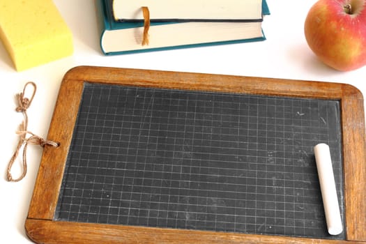 Old slate from school with chalk,sponge and apple