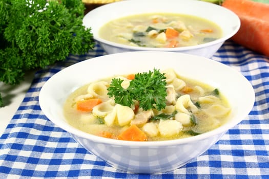 a bowl of chicken soup with fresh vegetables