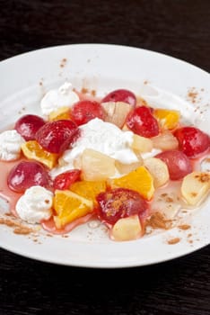 fruit salad of pineapple, grape, orange and strawberry with whipped cream