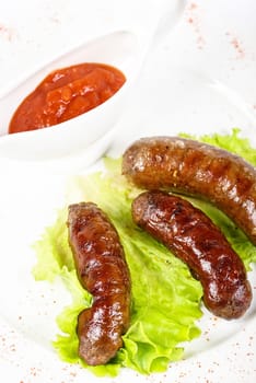 grilled venison sausage closeup with lettuce and sauce