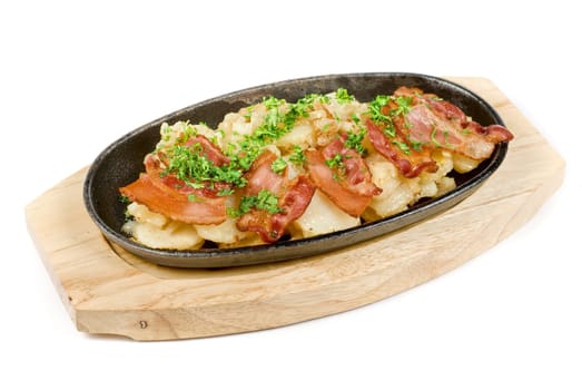 Fried potato with bacon and vegetables on a white