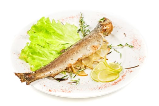 fish with lemon and greens on white background