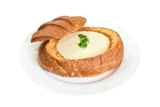 Cheese soup at baked bread as plate on a white background