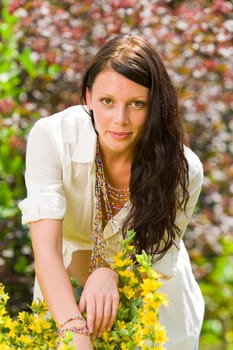 Beautiful young woman sunny garden care yellow flower portrait