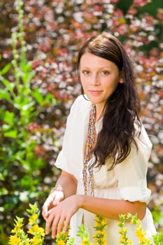 Beautiful young woman sunny garden care yellow flower portrait