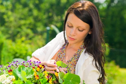 Summer garden beautiful young romantic woman with colorful flower portrait