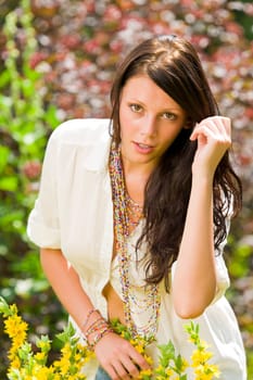 Beautiful young woman sunny garden care yellow flower portrait