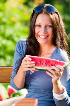 Cheerful young woman hold fresh melon summer garden terrace