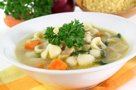 a bowl of chicken soup with fresh vegetables