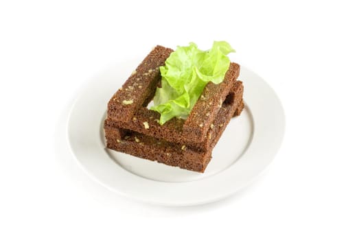 toasted bread closeup with garlic at lettuce leaf on white