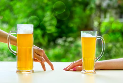 two hands, man and woman with beer in glass