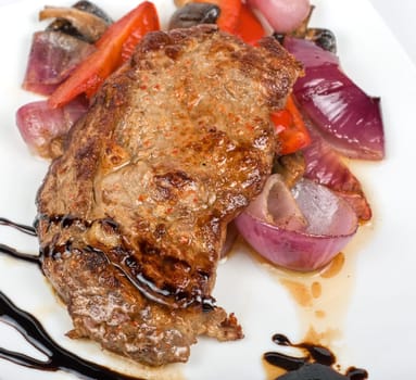 Roasted beef steak with vegetable closeup at plate