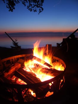 Blazing campfire at sunset along the beautiful beach of Lake Superior in northern Michigan.