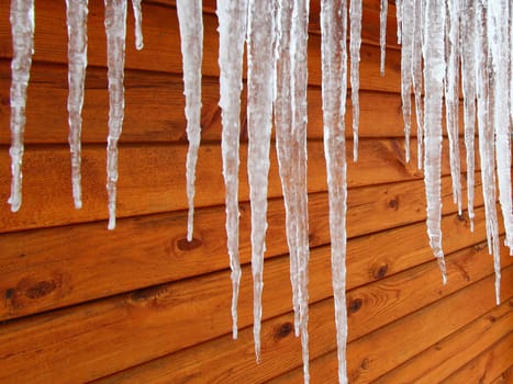 Icicles hang from a wood cabin in on a chilly winter day in northern America.