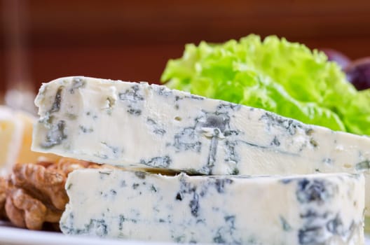 Blue cheese with lettuce, grapes and nuts closeup