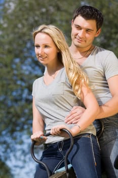 happy couple on a swing by summer day