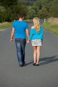happy couple walking on the road holding hands