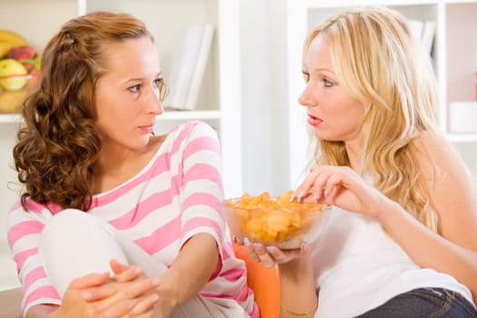 two women friends on sofa talking