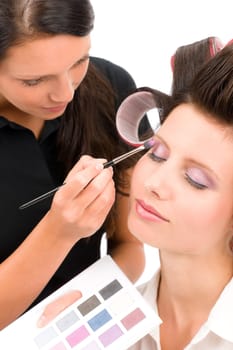 Make-up artist woman fashion model apply eyeshadow from color palette