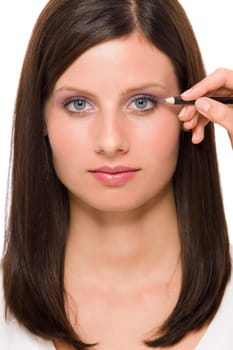 Portrait of beautiful woman making eye lines using pencil