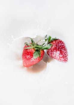 Top view of falling strawberries in a milk bath