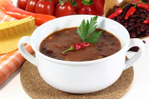 a cup of chili con carne and parsley