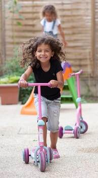 Smiling girl playing with a scooter
