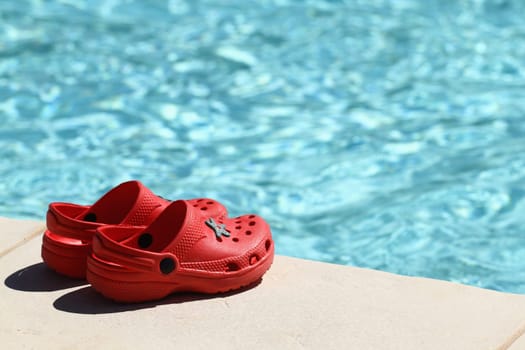 details of red sandals at poolside